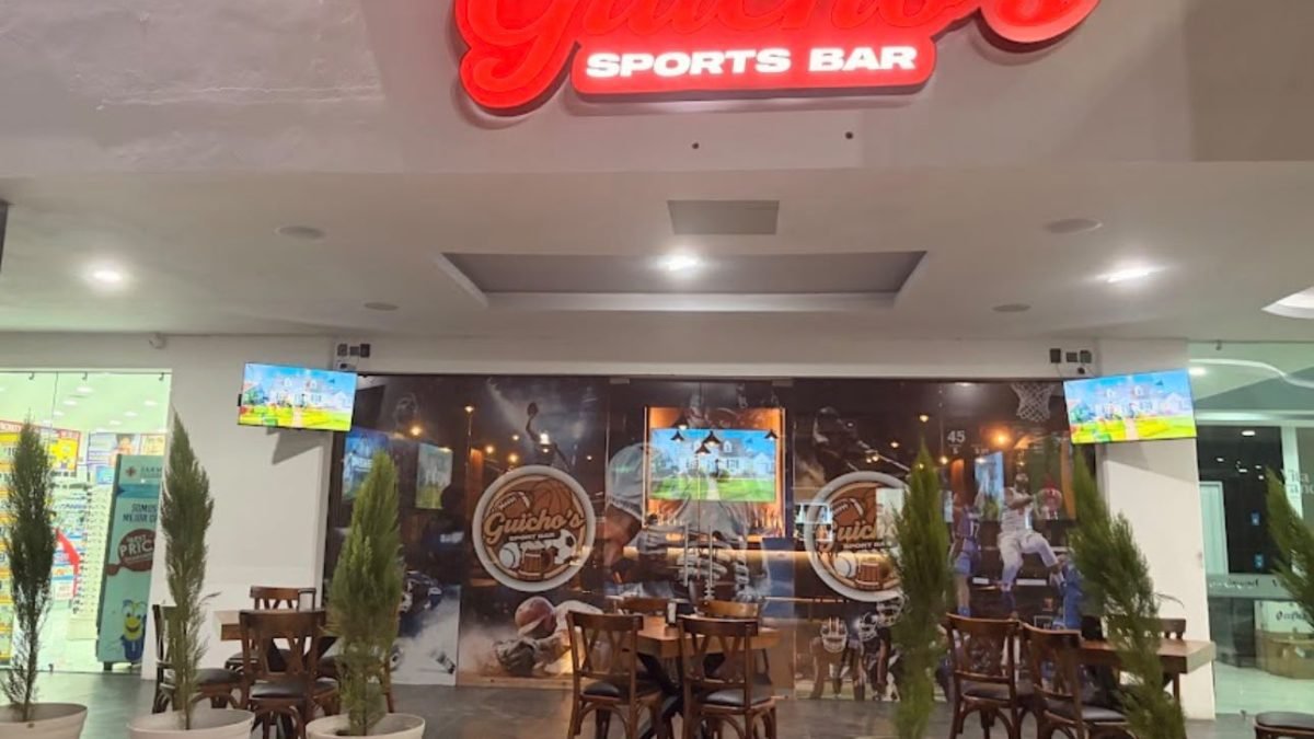 Entrance of Guicho's Sports Bar in Nuevo Vallarta, with red neon signage and outdoor plaza seating